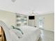 Serene main bedroom with light-colored walls, ceiling fan, a television, and access to a private balcony at 216 Palmetto Ave, Anna Maria, FL 34216