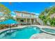 Inviting outdoor space with a swimming pool, lounge chairs, lush greenery, and two-story house view at 216 Palmetto Ave, Anna Maria, FL 34216