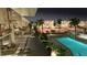 Exterior view of a community pool, palm trees, walkways and building balconies at dusk at 2170 Robinhood St # A1-304, Sarasota, FL 34231