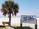 Scenic view of Siesta Beach with a palm tree and the beach sign at 2483 Bay St, Sarasota, FL 34237