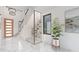 Bright foyer featuring marble floors, a glass-enclosed wine rack, and modern staircase at 2483 Bay St, Sarasota, FL 34237