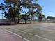 Outdoor basketball court surrounded by mature trees and fencing for recreational activities at 2700 Coconut Bay Ln # 432, Sarasota, FL 34237