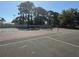 Well-maintained outdoor tennis court with net and fencing, surrounded by trees for privacy at 2700 Coconut Bay Ln # 432, Sarasota, FL 34237