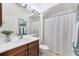 Cozy bathroom features a vanity with wood cabinets, framed mirror and shower with curtain at 2931 Bravura Lake Dr, Sarasota, FL 34240