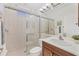 Bright bathroom features a tiled walk-in shower, wooden vanity, and a large mirror with modern lighting at 2931 Bravura Lake Dr, Sarasota, FL 34240