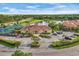 Community clubhouse featuring a lake, tennis courts, ample parking, and manicured grounds at 2931 Bravura Lake Dr, Sarasota, FL 34240