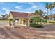 Exterior view of the community gate house, featuring a terracotta tile roof and manicured landscaping at 2931 Bravura Lake Dr, Sarasota, FL 34240