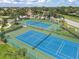 Aerial view of multiple tennis courts surrounded by lush landscaping and trees in a vibrant community at 2931 Bravura Lake Dr, Sarasota, FL 34240