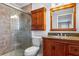 Stylish bathroom featuring a walk-in shower, wood cabinets, granite counters and updated fixtures at 2961 Valencia Rd, Venice, FL 34293