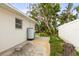 Exterior of home with lush landscaping, side utility access and white privacy fence at 2961 Valencia Rd, Venice, FL 34293