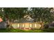 Beautiful home front, framed by mature trees at sunset at 2961 Valencia Rd, Venice, FL 34293