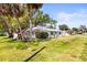 A single-story home with a well-manicured lawn and mature trees at 2961 Valencia Rd, Venice, FL 34293