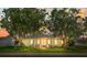 Charming single-story home with manicured lawn, lush trees and teal shutters at 2961 Valencia Rd, Venice, FL 34293