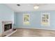 Bright living room featuring a fireplace, hardwood floors, and natural light from large windows at 2961 Valencia Rd, Venice, FL 34293