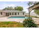 Backyard pool with brick trim next to back exterior of house and lush landscaping at 2961 Valencia Rd, Venice, FL 34293
