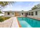 Backyard pool with brick trim next to back exterior of house and lush landscaping at 2961 Valencia Rd, Venice, FL 34293