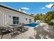 Relaxing backyard with a sparkling pool, table with four chairs, and lush tropical landscaping creating a private oasis at 305 73Rd St, Holmes Beach, FL 34217