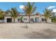 Charming one-story home featuring a white exterior with a blue front door and well-maintained landscaping at 305 73Rd St, Holmes Beach, FL 34217