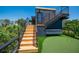 The modern home has a putting green and external wooden stairs leading to the rooftop deck at 315 N Bay Blvd, Anna Maria, FL 34216