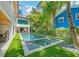 Beautiful backyard with a refreshing pool, lush landscaping, and turf at 315 N Bay Blvd, Anna Maria, FL 34216