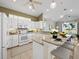 Bright kitchen with white cabinetry, stone countertops, stainless appliances and bar seating at 3835 Alamanda Dr, Sarasota, FL 34238