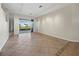 Open living space with tiled floors, track lighting, and a sliding glass door leading to a screened patio at 3835 Alamanda Dr, Sarasota, FL 34238