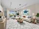 Inviting living room featuring a plush white sofa, modern art, and a seamless transition to the outdoor patio area at 3835 Alamanda Dr, Sarasota, FL 34238