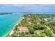 Aerial view features waterfront homes adjacent to a sandy beach and clear blue waters at 4050 Higel Ave, Sarasota, FL 34242