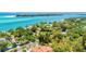 Stunning overhead captures beachfront homes, lush foliage, and calm ocean waters at 4050 Higel Ave, Sarasota, FL 34242