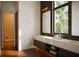 Modern bathroom with double vanity, sleek fixtures, and large window with tropical view and sauna at 4050 Higel Ave, Sarasota, FL 34242