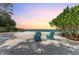 Tranquil beach setting featuring two inviting blue Adirondack chairs on the sandy shore at 4050 Higel Ave, Sarasota, FL 34242