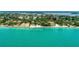 An aerial view shows a line of beachfront homes on clear turquoise water at 4050 Higel Ave, Sarasota, FL 34242