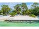 Idyllic beachfront property with lounge chairs, clear water, and lush tropical landscaping at 4050 Higel Ave, Sarasota, FL 34242