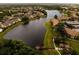 Aerial view of a lakeside community featuring multiple buildings, a pier, and mature trees at 4061 Crockers Lake Blvd # 2618, Sarasota, FL 34238