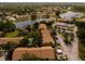 Wide aerial view of a condo community on a large lake with lush green spaces at 4061 Crockers Lake Blvd # 2618, Sarasota, FL 34238
