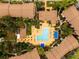 A nice community pool is surrounded by lounge chairs, blue umbrellas, and tropical foliage at 4061 Crockers Lake Blvd # 2618, Sarasota, FL 34238