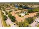 Wide aerial view featuring community amenities, lush landscaping, and the nearby lake at 4061 Crockers Lake Blvd # 2618, Sarasota, FL 34238