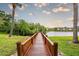 Community dock on a lake with palm trees lining the sides and apartment buildings in the distance at 4061 Crockers Lake Blvd # 2618, Sarasota, FL 34238