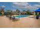 Community pool surrounded by lounge chairs and buildings with tan walls and brown roofs at 4061 Crockers Lake Blvd # 2618, Sarasota, FL 34238