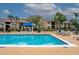Community pool with buildings in the background and lounge chairs on the tan-colored deck at 4061 Crockers Lake Blvd # 2618, Sarasota, FL 34238
