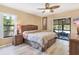 Comfortable bedroom with a ceiling fan, light-colored walls, wood-look floors, and patio access at 4169 66Th Street W Cir # 4169, Bradenton, FL 34209