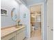Bright bathroom features neutral vanity with an oval mirror and walk-in shower at 4355 Longmeadow # 23, Sarasota, FL 34235