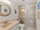 Bathroom with light stone countertop and decorative fish art near frosted glass shower at 4355 Longmeadow # 23, Sarasota, FL 34235