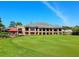 Exterior of a community clubhouse with large windows, green lawn, and golf course at 4355 Longmeadow # 23, Sarasota, FL 34235