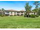 Exterior of condominium building with well-maintained lawn and mature trees at 4355 Longmeadow # 23, Sarasota, FL 34235