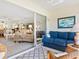 Relaxing Florida room featuring a comfortable blue couch, wicker furniture, and sliding glass doors at 4355 Longmeadow # 23, Sarasota, FL 34235