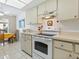 The white kitchen includes an electric range with adjacent cabinets and plenty of countertop space at 4355 Longmeadow # 23, Sarasota, FL 34235