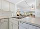 A well-lit kitchen sink offers lots of counter space with mirrored backsplash and white dishwasher at 4355 Longmeadow # 23, Sarasota, FL 34235