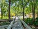 Wooden walkway leads through lush greenery to community pool with lifeguard stand at 4355 Longmeadow # 23, Sarasota, FL 34235