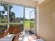 The screened porch offers views of the golf course with a welcome mat and a comfortable chair at 4355 Longmeadow # 23, Sarasota, FL 34235